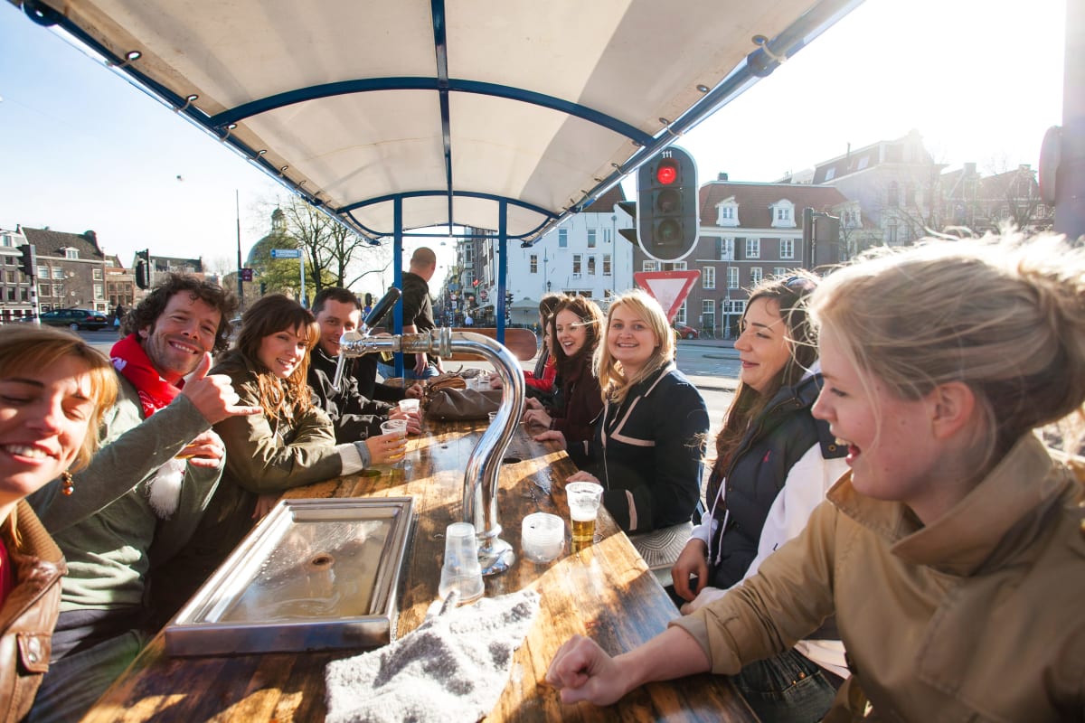 A happy laughing hen group on a beer bike