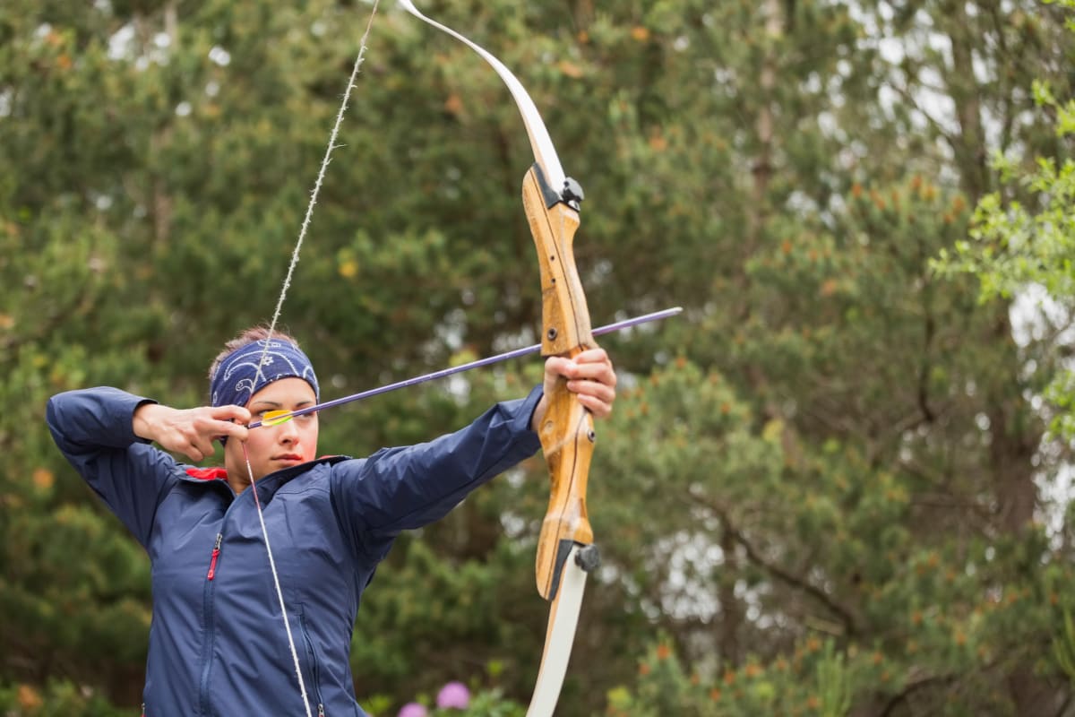 Person shooting bow and arrow in archery