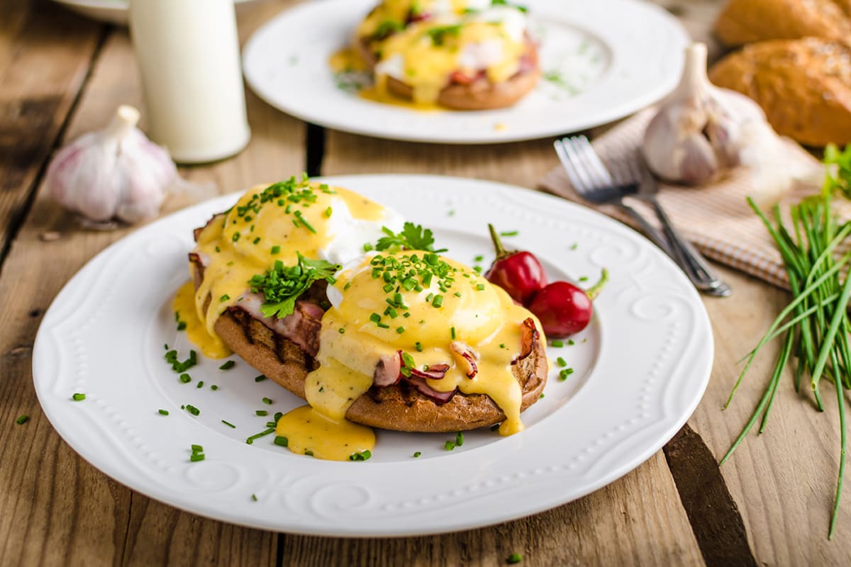 Eggs Benedict with little salad, milk and fresh herbs_brunch_breakfast