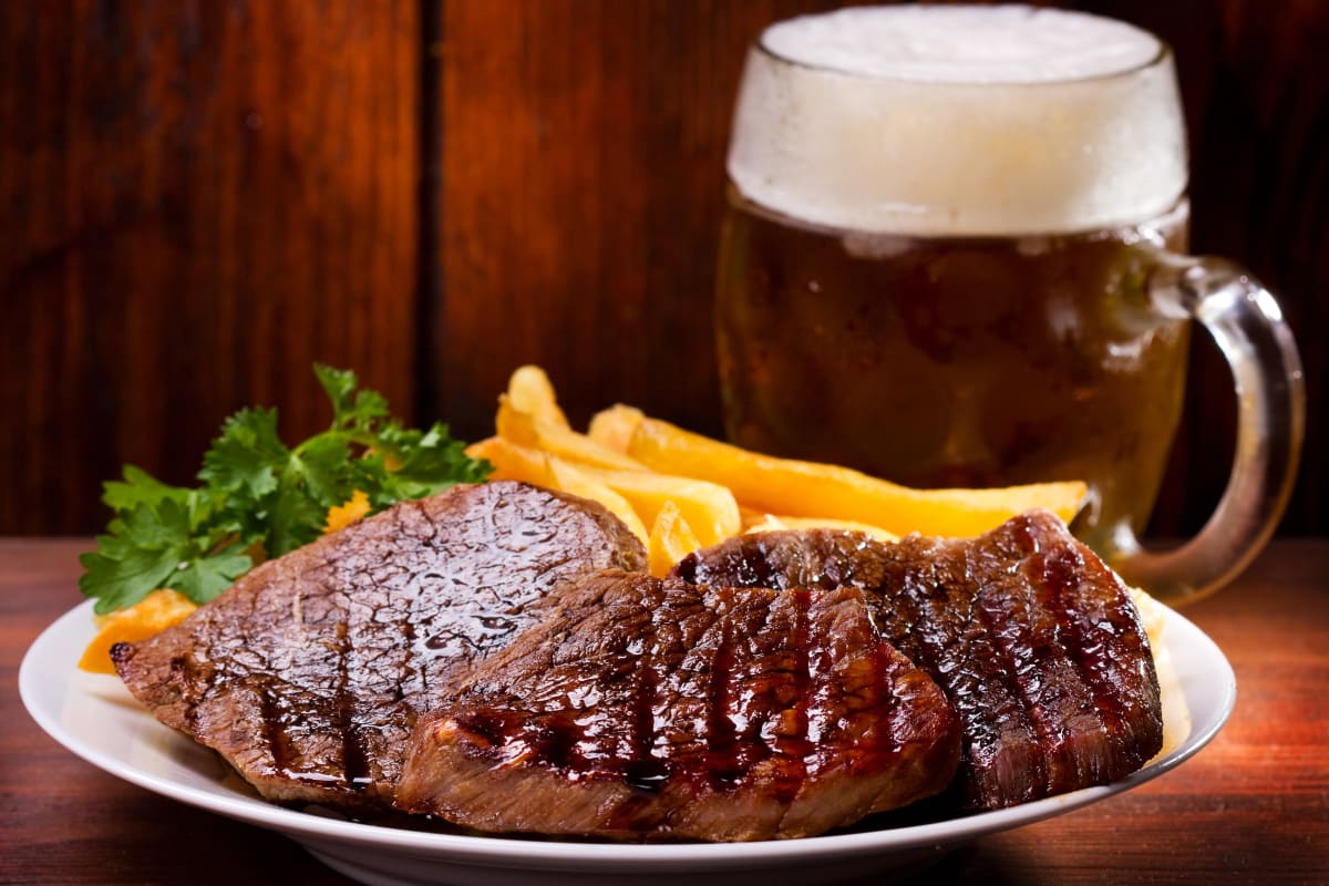 A plate of steak and a pint of beer