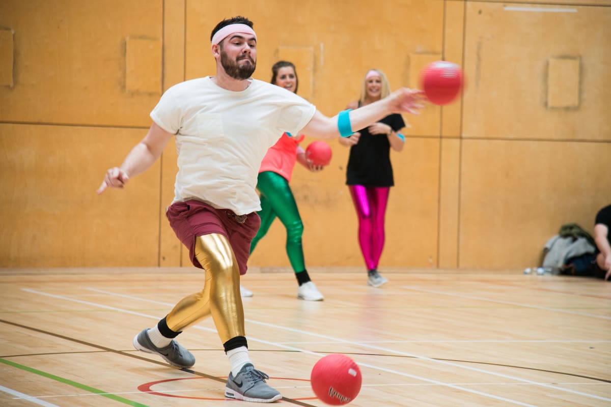 A man throwing a ball during a game of dodgeball