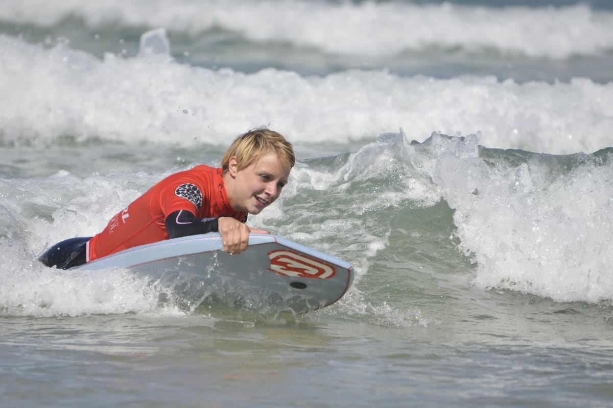 A happy woman enjoying a body boarding lesson