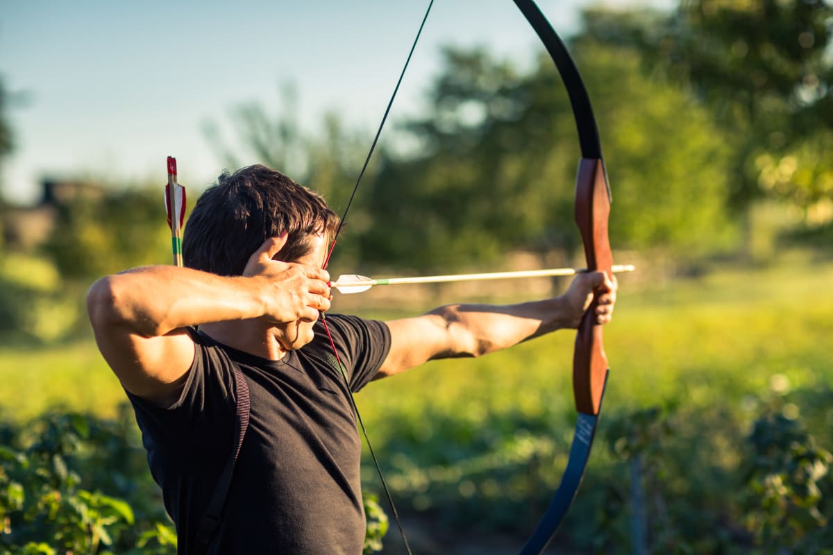 a man fires a bow and arrow