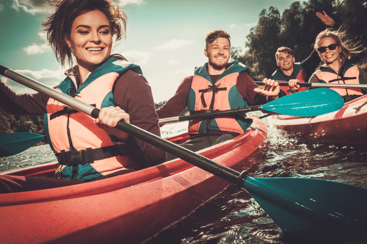 happy friends enjoying kayaking on river two seat kayak