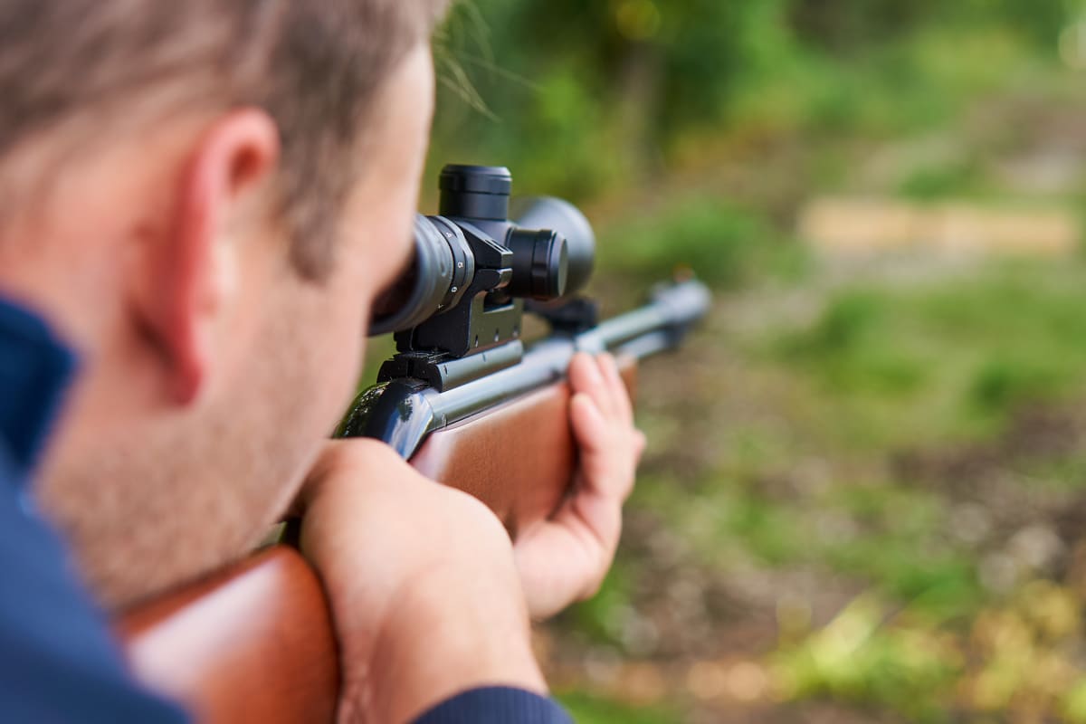 man with air rifle shooting