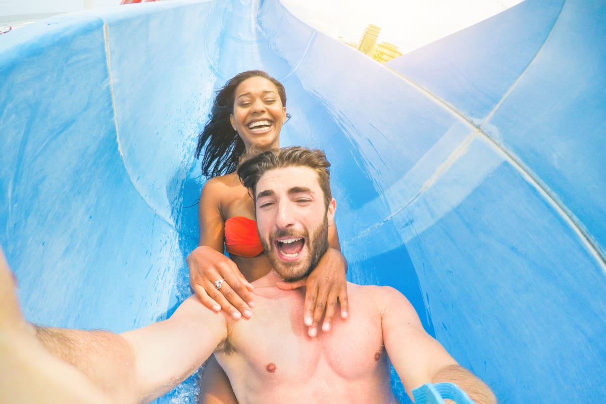 couple having fun at water park on ride
