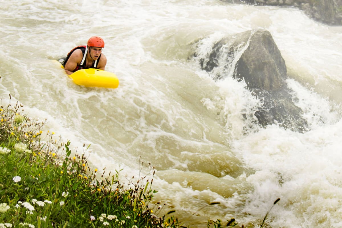 A man going down the rapids on a hydro speed