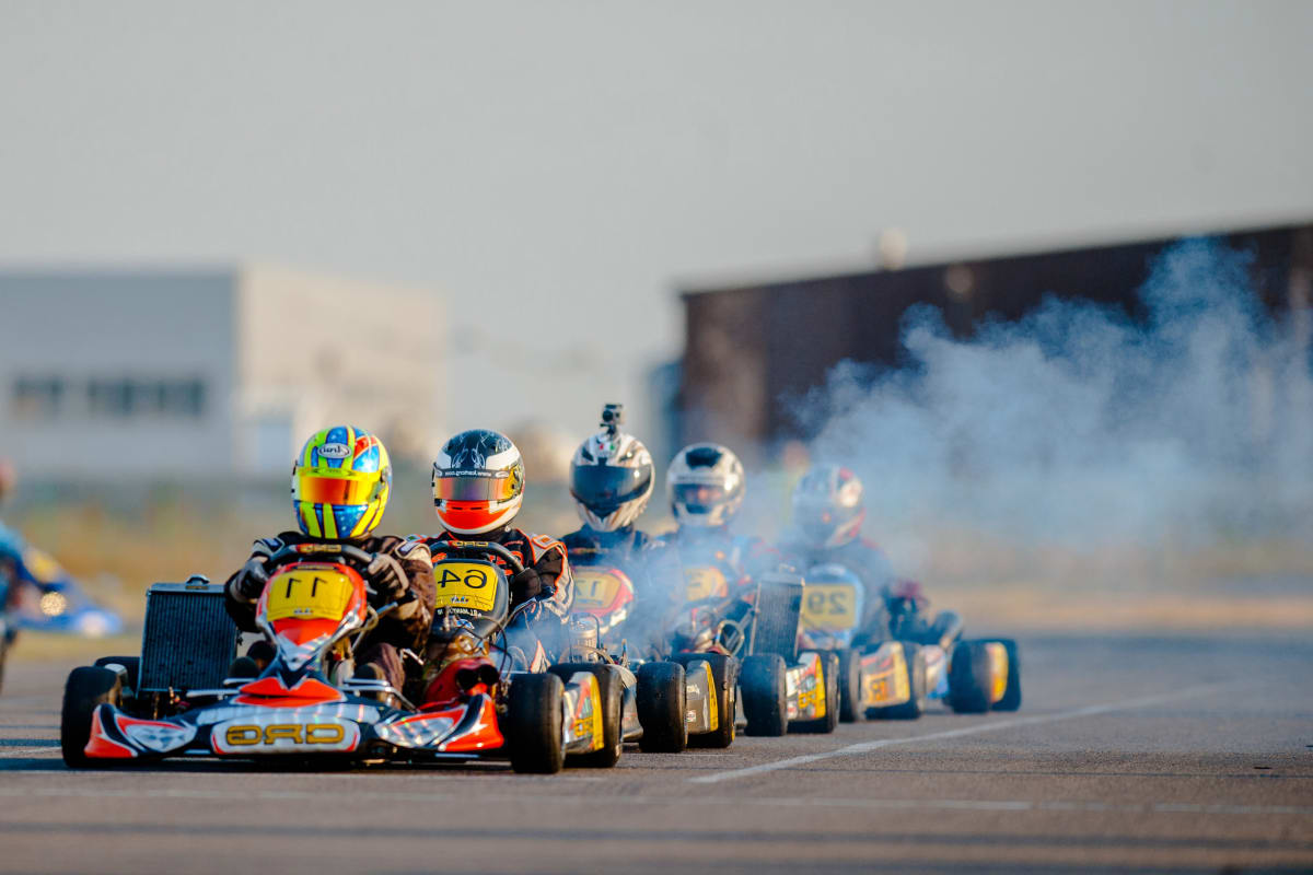 A group of guys racing go karts on a stag weekend