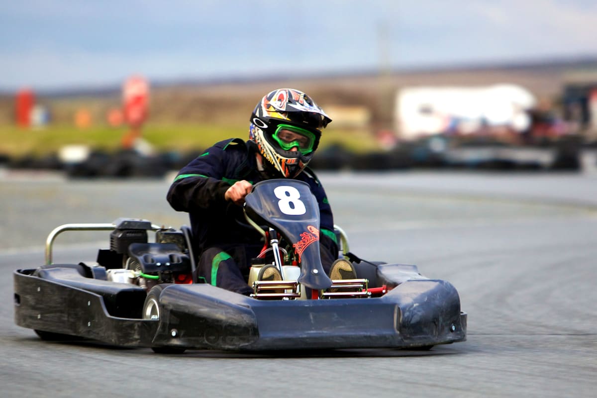 A man in a go kart racing around a track