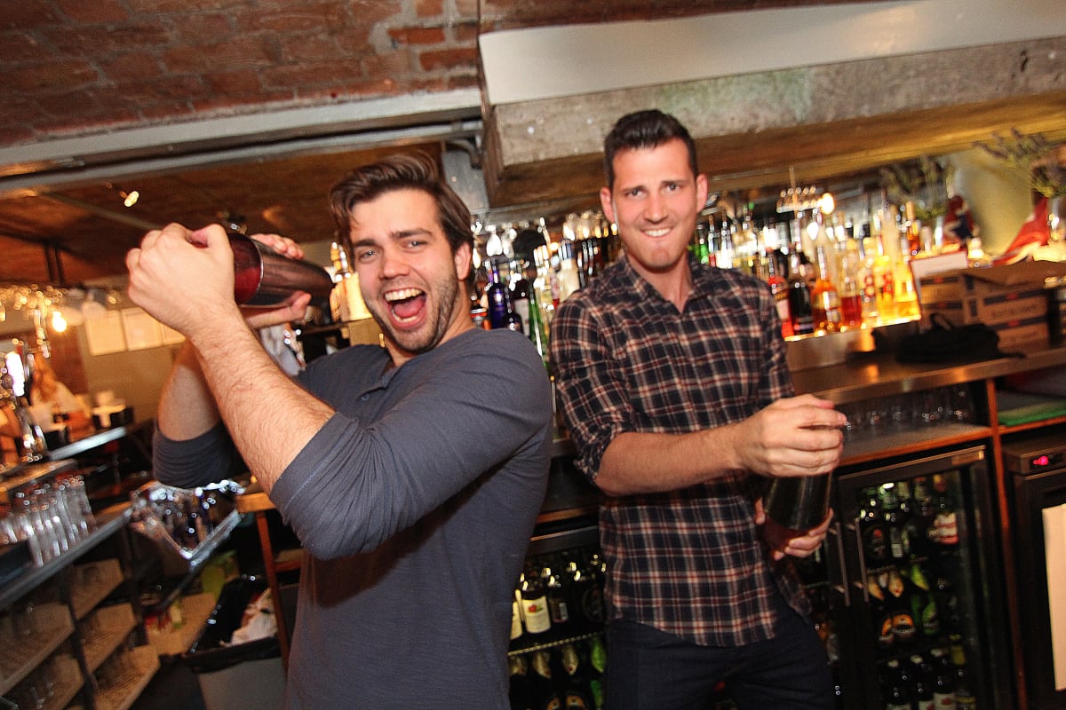 Two happy members of a stag party making cocktails