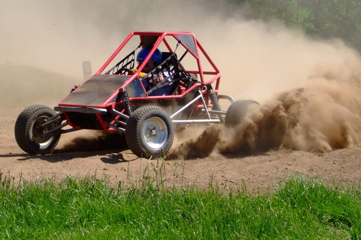 a man races around a muddy track in a rage buggy
