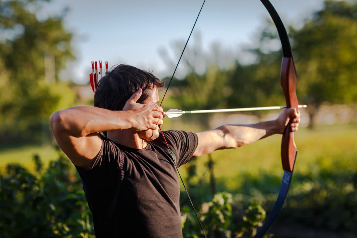 Person shooting bow and arrow in archery