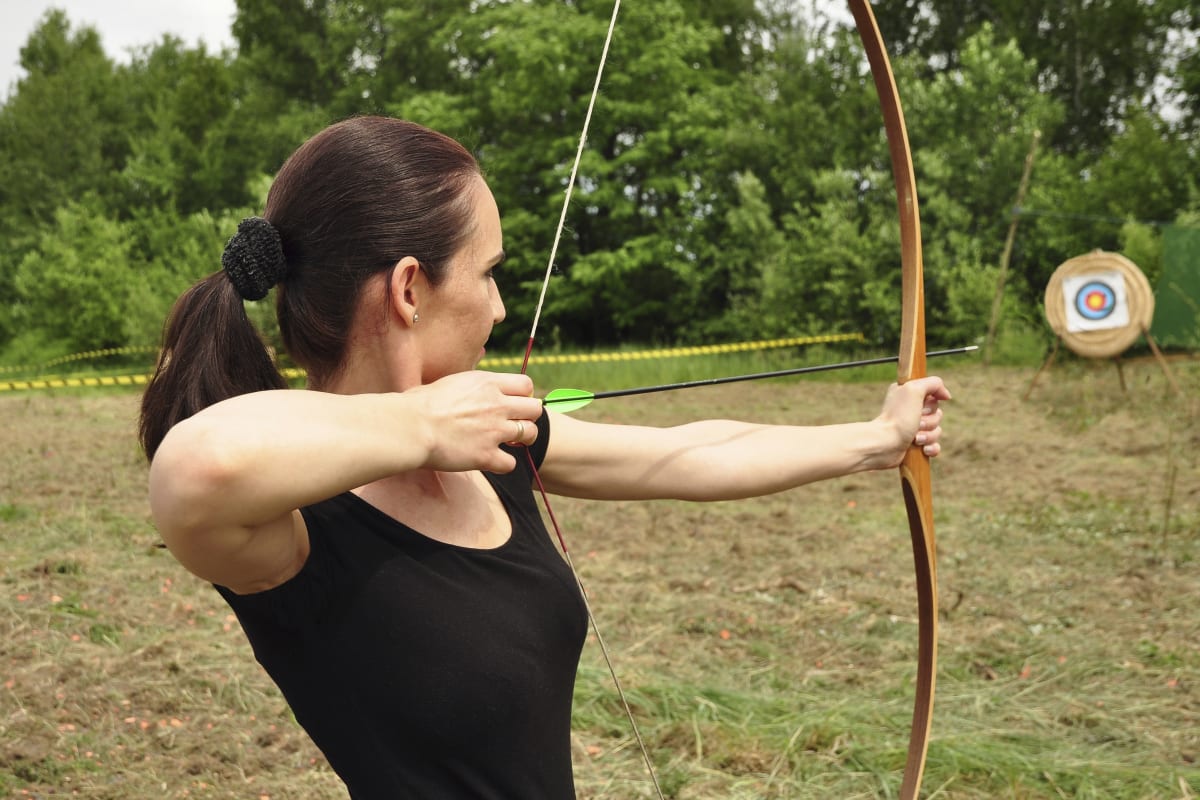 A woman shooting a bow and arrow