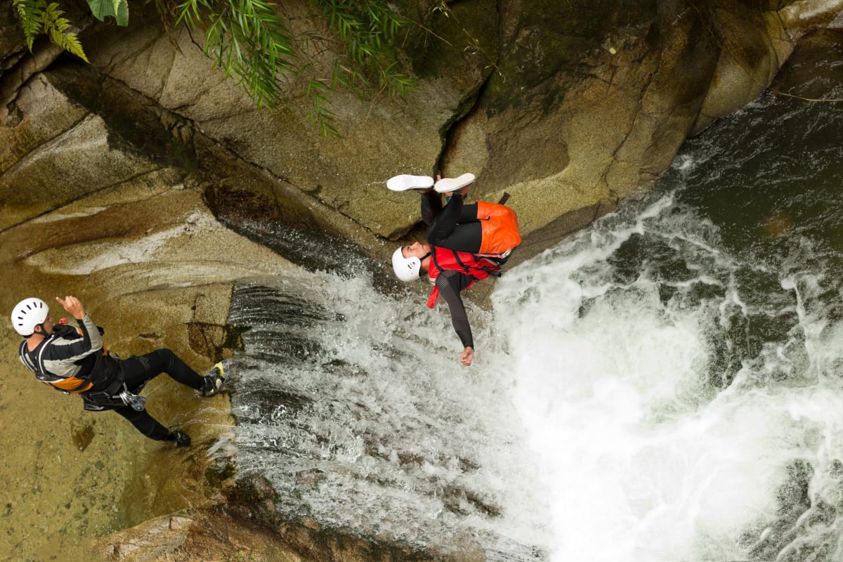 man jumping from cliff whilst canyoning