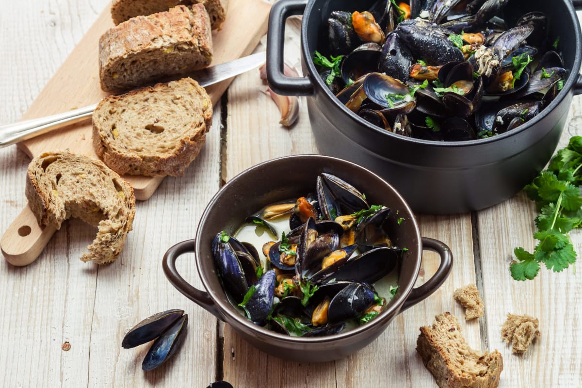 a bowl of mussels with bread