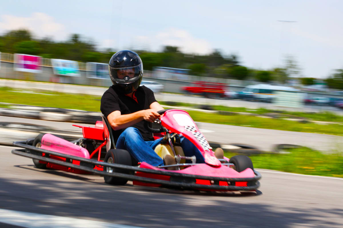 A group of guys racing go karts on a stag weekend