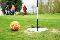 A group of men playing foot golf
