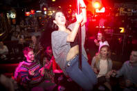 A woman dances on the bar during a bar crawl