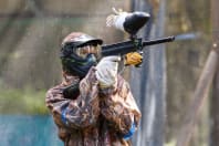 A man fires a  paintball gun