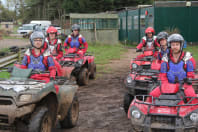 A happy stag group sitting on quad bikes