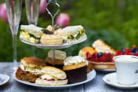 A cake tray with sandwiches and cakes on it