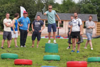 A laughing stag party throw a wellington boot for highland games