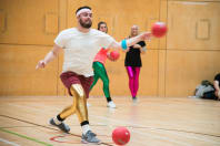 A man throwing a ball during a game of dodgeball