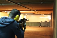 A man shooting a machine gun AK47