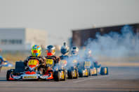 A group of guys racing go karts on a stag weekend