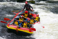 a group of people going down rapids on a raft