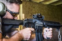 A man shooting an assault rifle