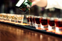 a bar man pours shots on a bar