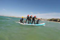 A stag group having fun on a giant standup paddle board