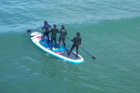 A stag group having fun on a giant standup paddle board