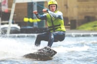a man being towed on a cable wakeboarding