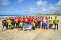 A large stag group participating in a cornish beach games activity