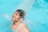 Happy Young Man Having Fun and Relaxing Under a Water Jet