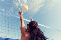 a woman playing beach volleyball