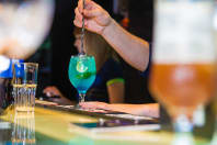 A woman pouring a cocktail during a cocktail making class