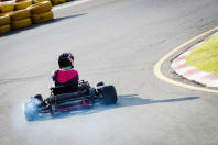 a woman races round a track whilst go karting