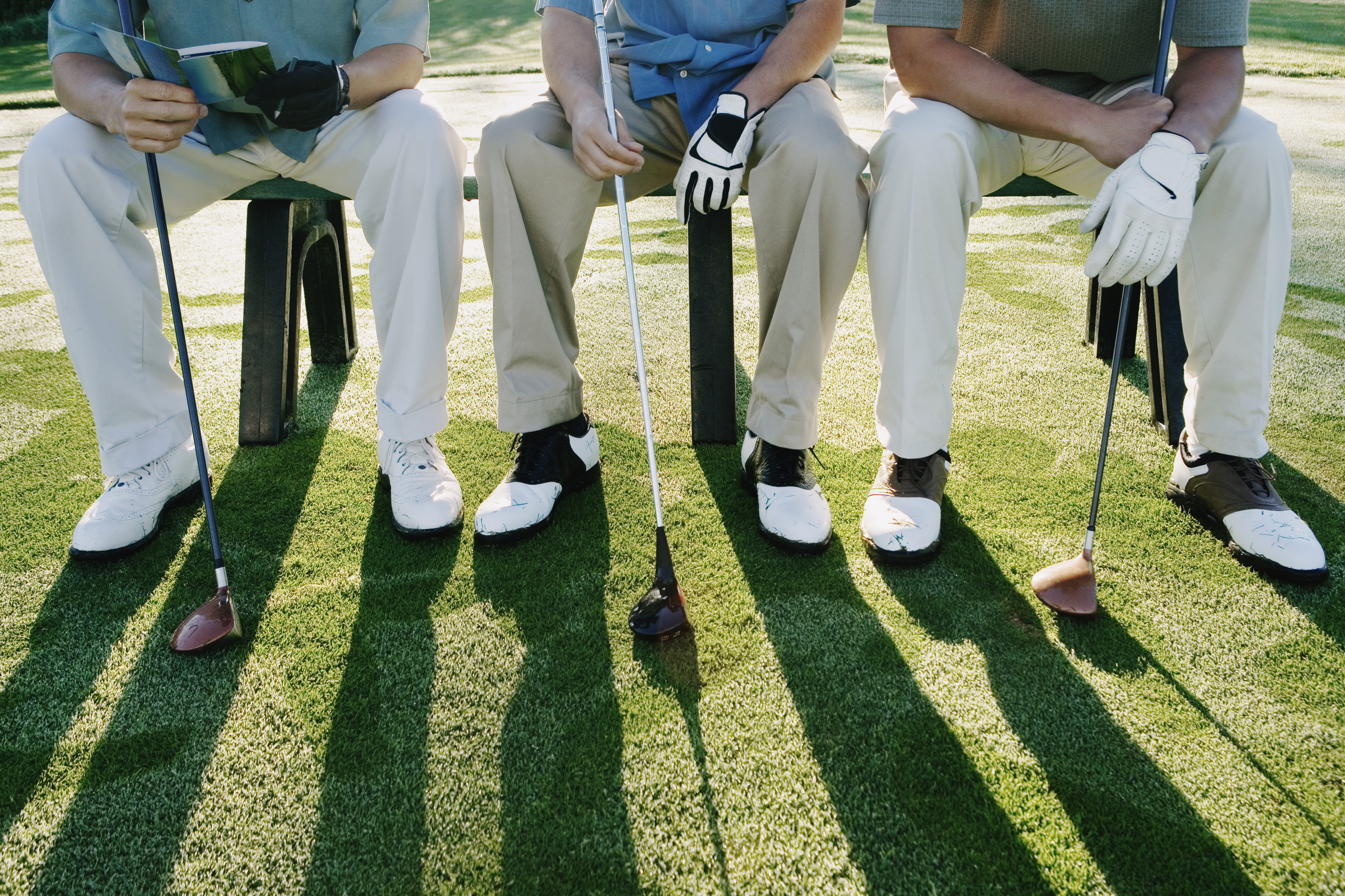 three men with golf clubs