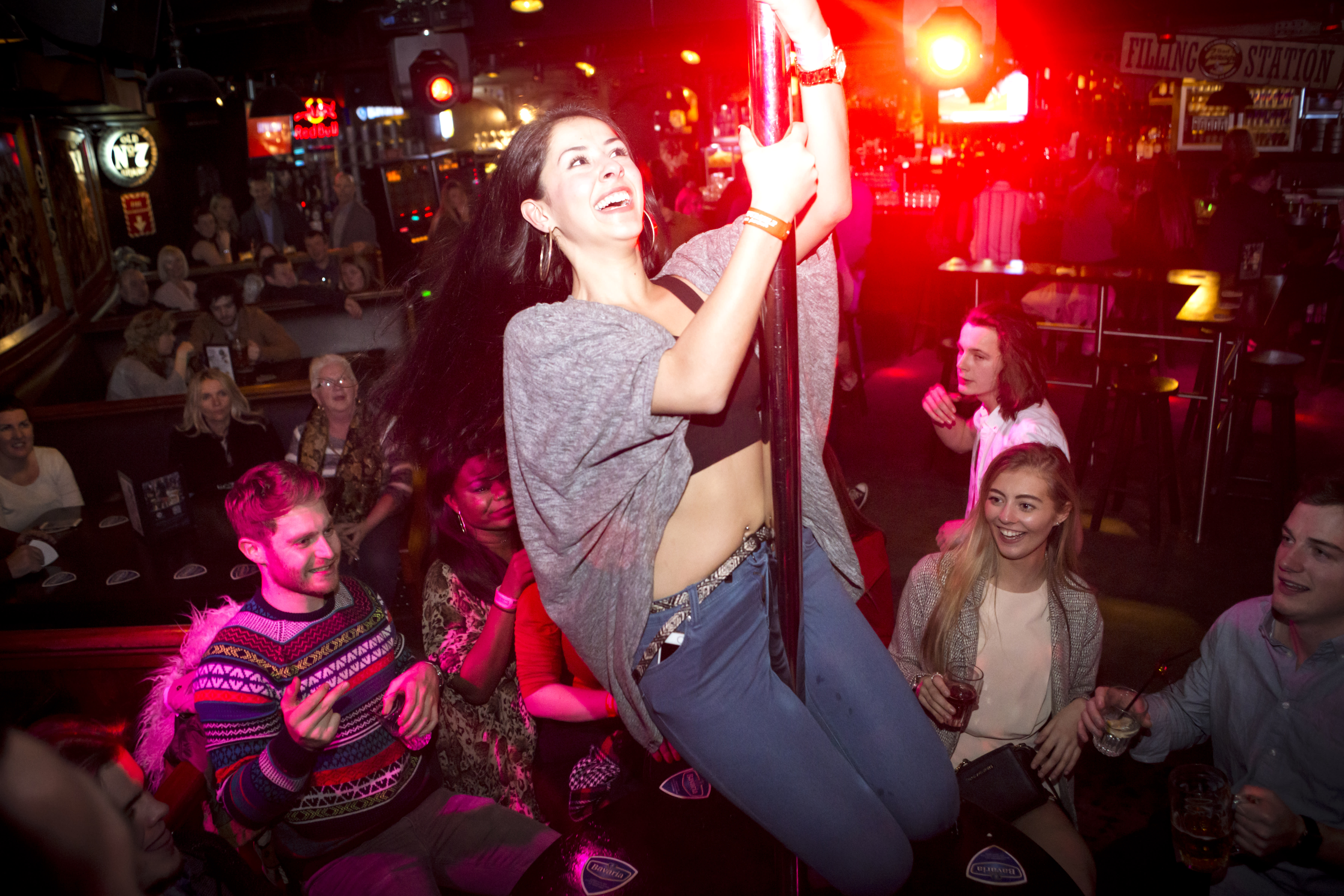 A woman dances on the bar during a bar crawl