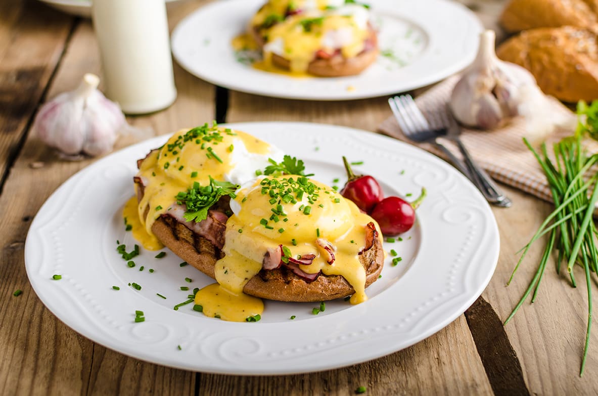 Eggs Benedict with little salad, milk and fresh herbs_brunch_breakfast