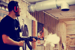 A man shooting a machine gun AK47