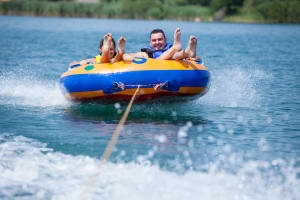 Two people on a ringo behind a speedboat
