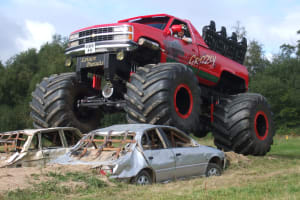 A monster truck driving over cars