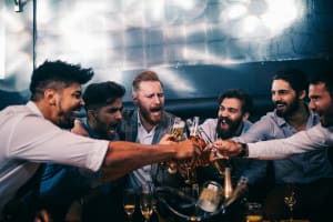 Group of men toasting a beer at a nightclub