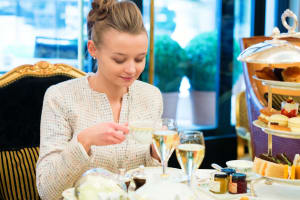 An attractive woman having a champagne afternoon tea