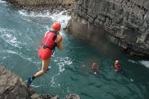A stag group jumping from a cliff during coasteering