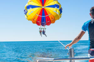 Happy couple parasailing over blue water